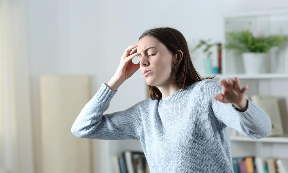 Woman experiencing sudden dizziness and lightheadedness at home